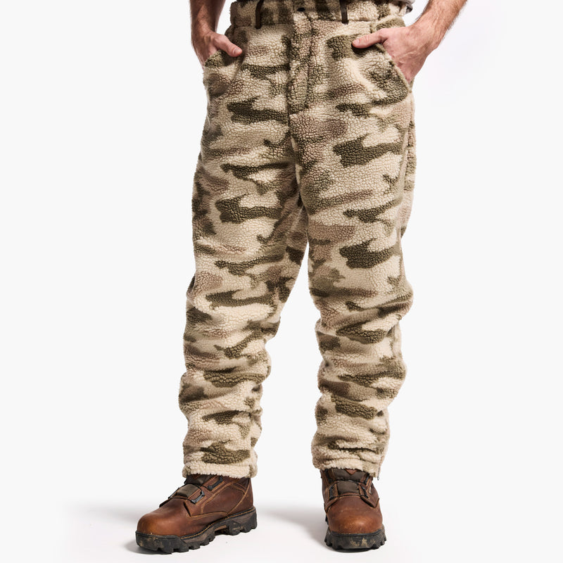 Camouflage pants worn by a person on a white background