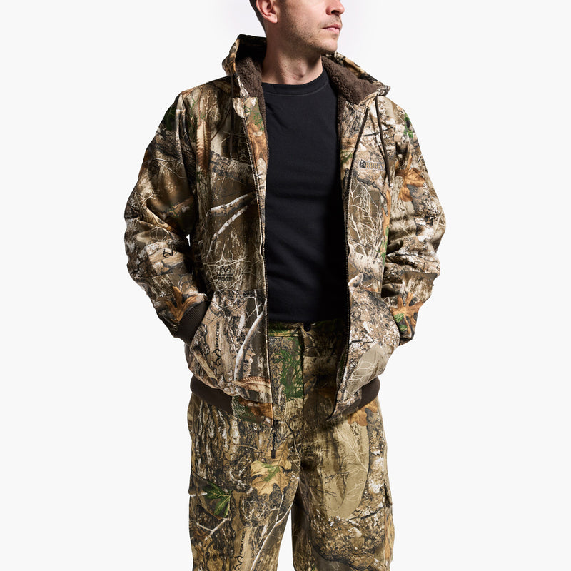 Person wearing a camouflage jacket and pants on a white background