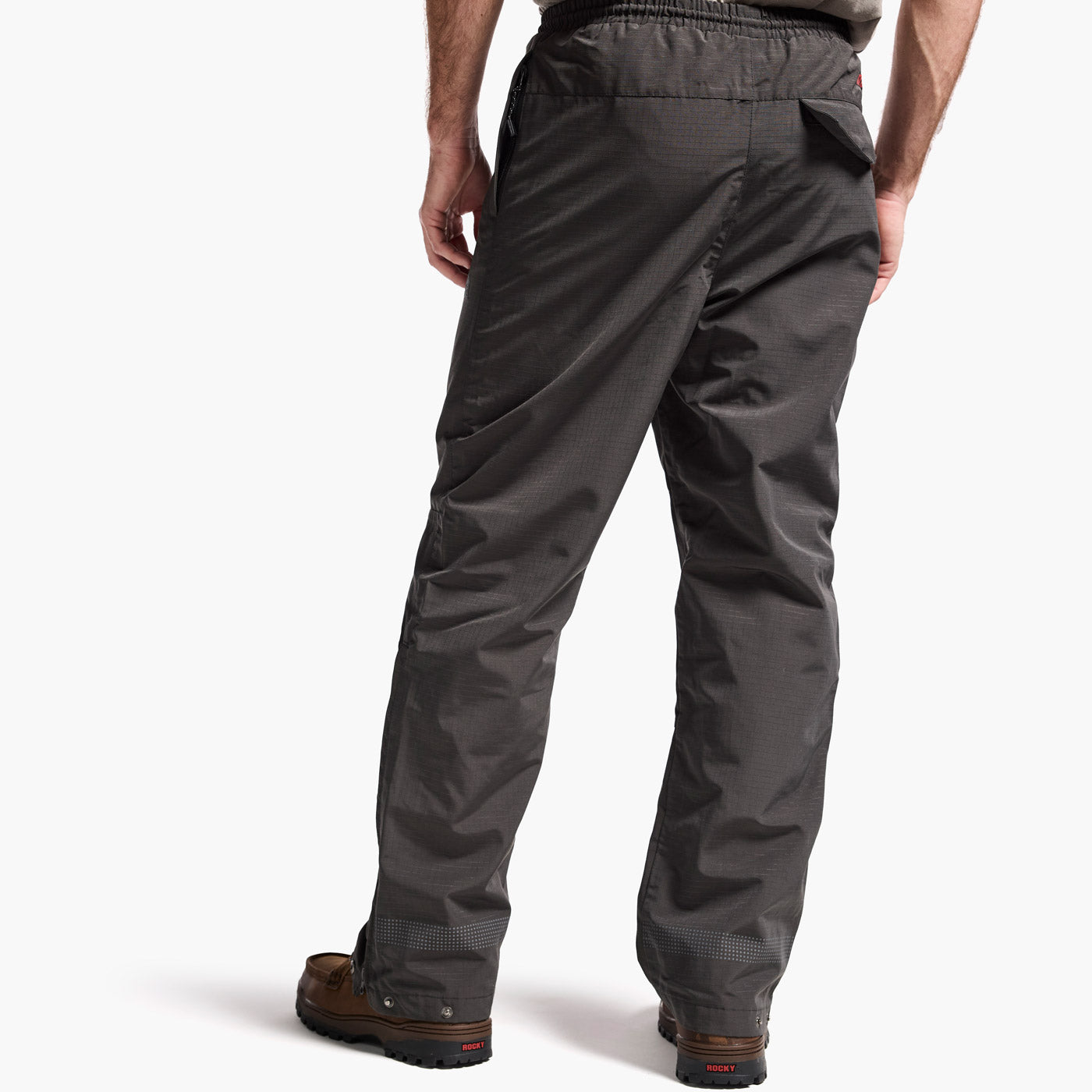 Person wearing dark gray pants on a white background